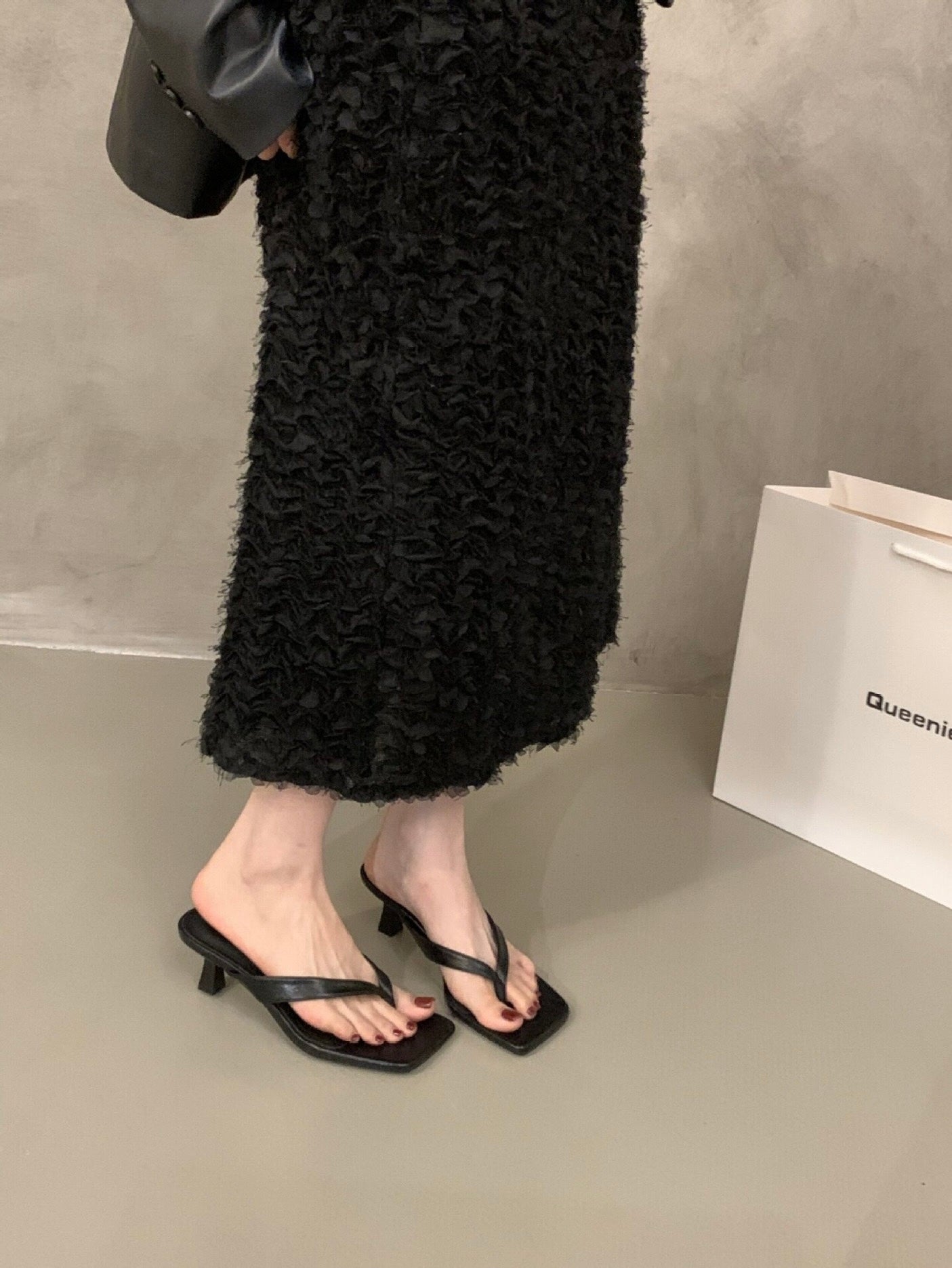 Black Camille kitten heel sandals worn with a black skirt