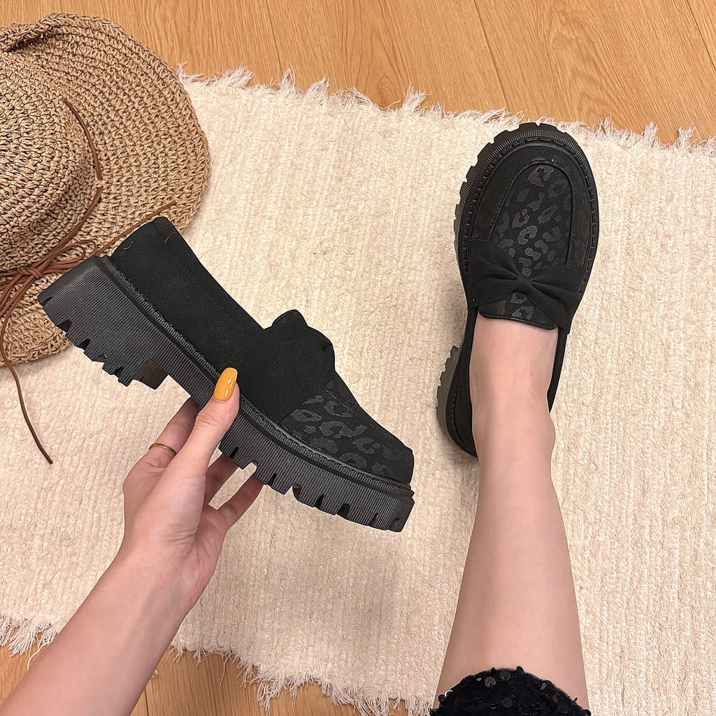 Black leopard-print bow platform loafers styled on foot